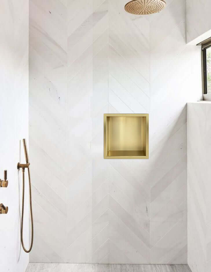 Excellence inbouwnis in geborsteld messing goud geïntegreerd in moderne badkamer muur.